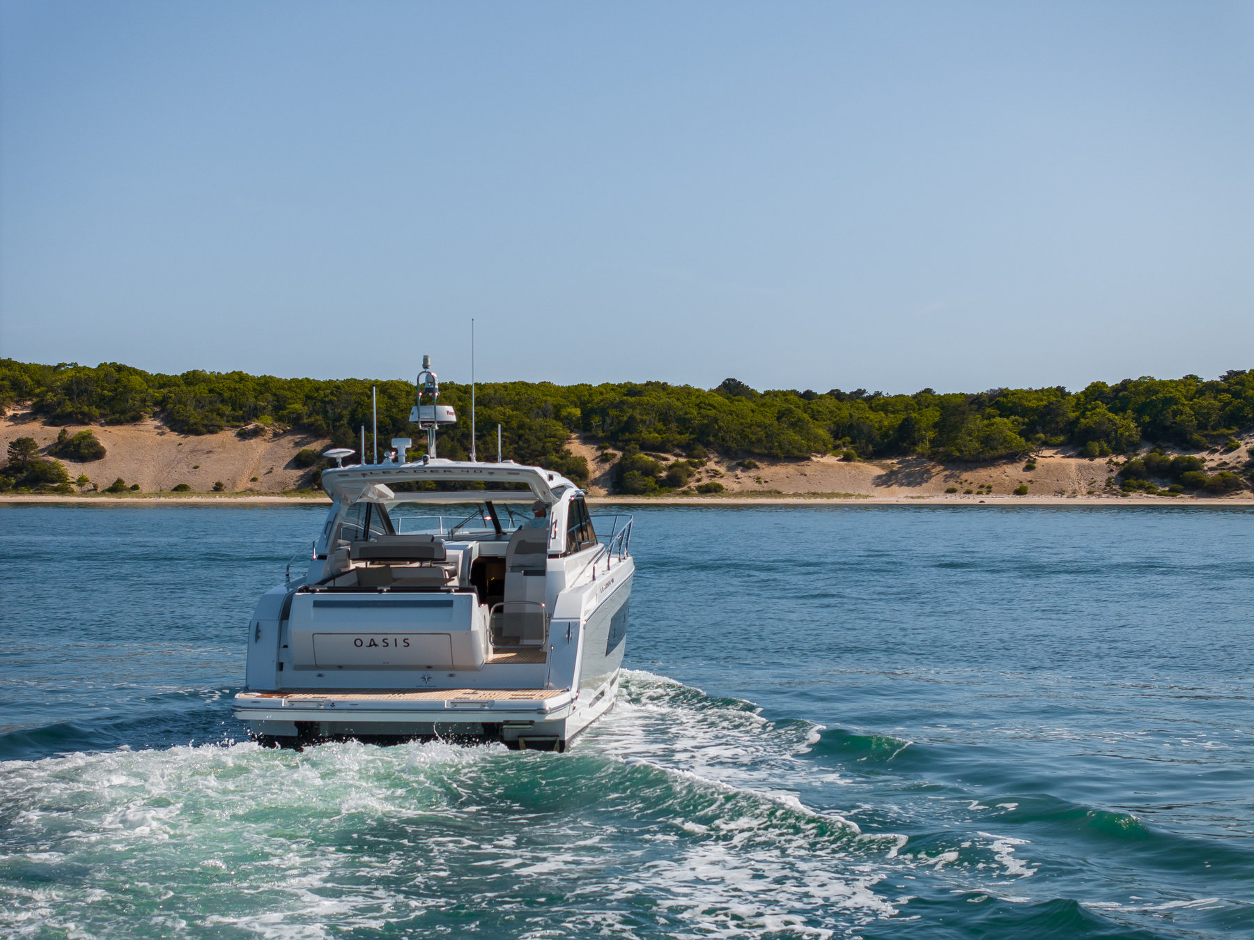 The Oasis yacht underway with a white wake behind it
